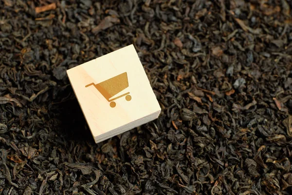 Abstract cart on a wooden cube and dry black tea. The concept of procurement of goods. — 图库照片