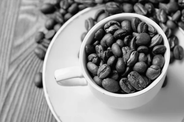 Tinte blanco y negro. Una taza de café espresso llena de granos de café . — Foto de Stock