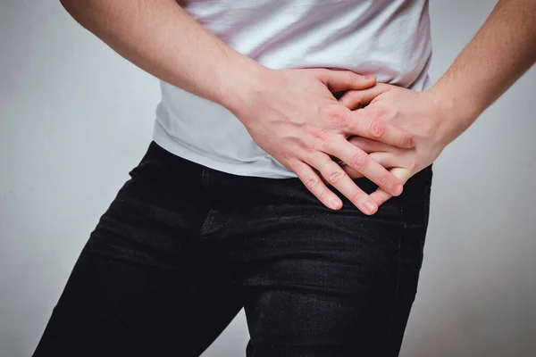 A man in a white T-shirt suffers from pain in his left side. The concept of problems with a stomach ulcer, gastritis, spleen. Toned. — Stock Photo, Image