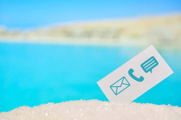 Abstract beach sand on a background of the sea with mountains with a contact card - phone, mail, envelope, message. Messenger. Copy space. — Stockfoto