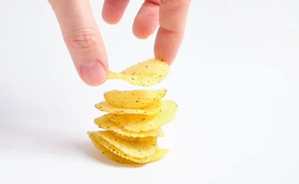 A man builds a stack of chips with his hand. The concept of delicious perfect cooked. — Stockfoto