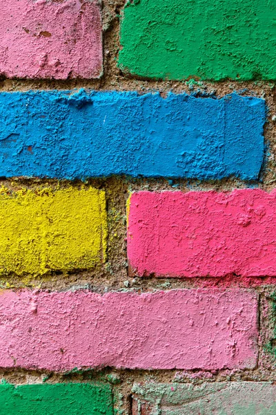 brick wall in different colors painted. Vertical. Close up.
