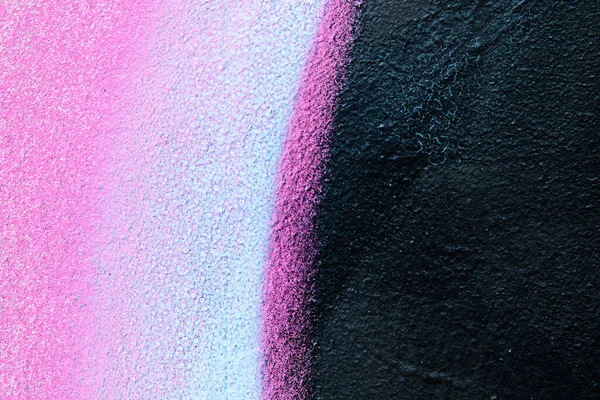 Abstract metal texture with a spray paint line of pink, white and black color. Close up.