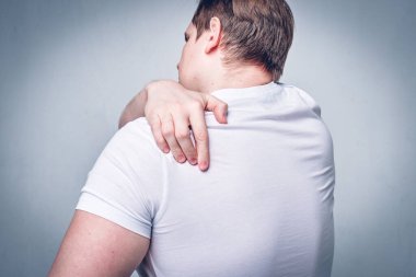 Bir adam boynuna masaj yapar, sırtını kaşır. Şiddetli kaşıntı. Alerji reaksiyonu. Ton halinde. Kapat..