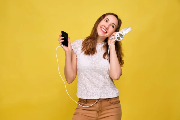 Ein Mädchen Sommerkleidung Steht Vor Gelbem Hintergrund Und Nimmt Musik — Stockfoto