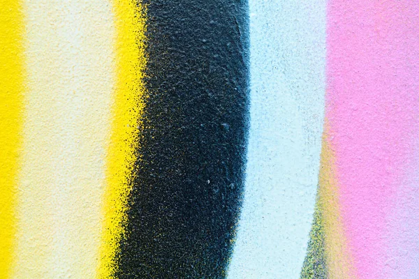 Abstract metal texture with a spray paint line of pink, white, yellow and black color. Close up.