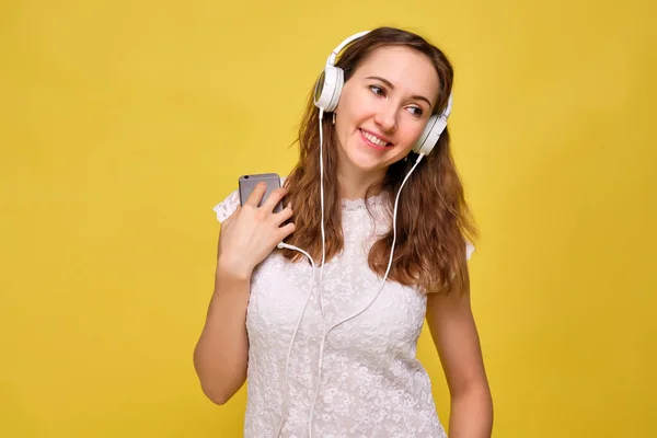 Dívka Letním Oblečení Stojí Žlutém Pozadí Poslouchá Hudbu Bílých Sluchátkách — Stock fotografie