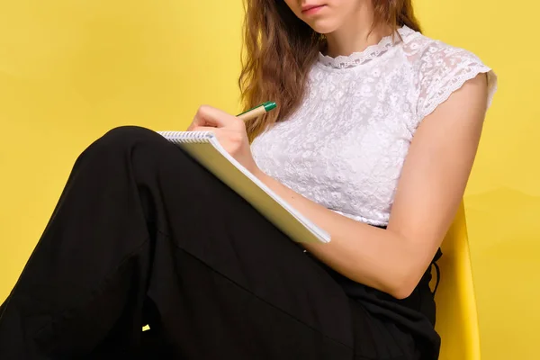 Κορίτσι Κίτρινο Φόντο Κάθεται Κάτω Σημειώσεις Κλείσε — Φωτογραφία Αρχείου