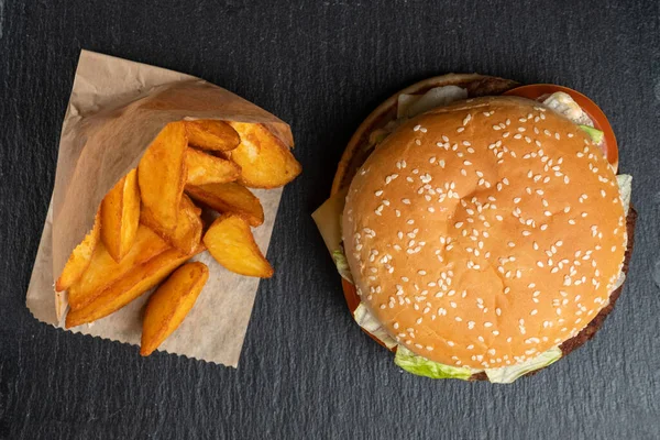 Kağıt Üzerinde Patates Hamburgerin Yanında Siyah Taş Tabaklarda Üst Manzara — Stok fotoğraf