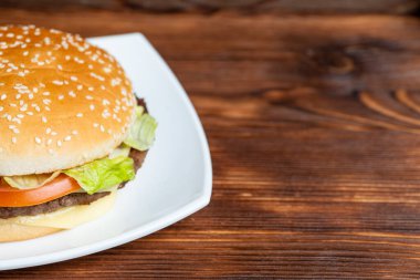 Tabakta hamburger ve ahşap arka plan. Uzayı kopyala Kapat..