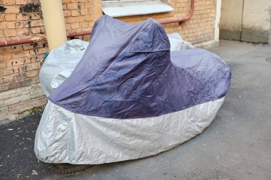Motosikletteki koruyucu kumaş pelerini. Dışarı çıkın. Kapat..