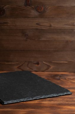 Çanak çömlek, ahşap zemin üzerinde siyah bir taş. Kapat..