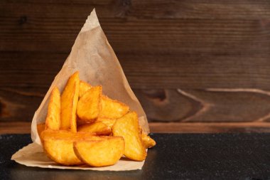 Patates rustik sofra takımı, ahşap zemin üzerinde siyah taş. Kapatın. Boşluğu kopyala.