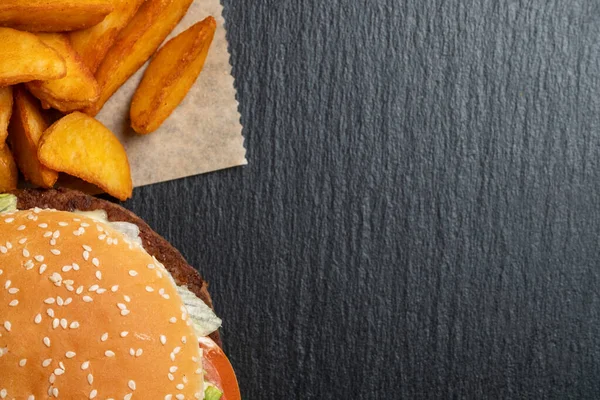 Kağıt Üzerinde Patates Hamburgerin Yanında Siyah Taş Tabaklarda Üst Manzara — Stok fotoğraf