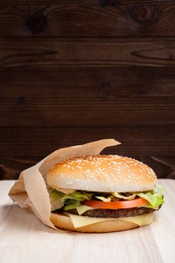 Ahşap bir arka planda, kenardan genel hamburger manzarası. Kapatın. Dikey.