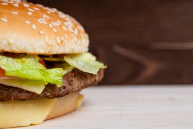 Ahşap bir arka planda hamburger. Değerlendirme konsepti. Uzayı kopyala Kapat..