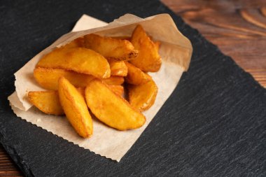 Patates rustik sofra takımı, ahşap zemin üzerinde siyah taş. Kapat..