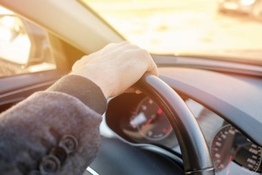 Modern arabadaki bir adam. Direksiyonu soğuk ve cüretkar tutan eller. Kapat..