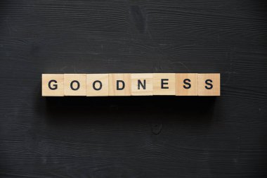 Modern iş için anahtar kelime: iyilik. Tahtadaki tahta bloklu üst manzara. Kapatın. Üst görünüm.