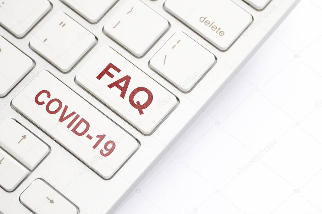 Keyboard inscription FAQ and COVID-19. Close up.