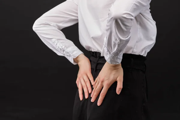 Girl White Shirt Massages Lower Back Black Background Close — Stock Photo, Image