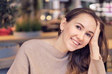 Kafede bir kız kameraya gülümsüyor. Kapat..