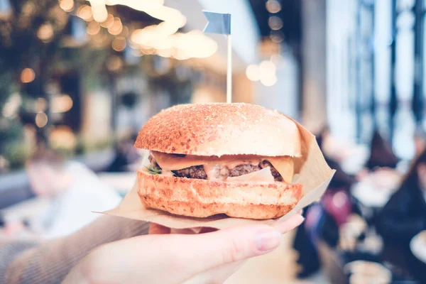 Kız Restoranın Arka Planında Bir Hamburger Tutuyor Ton Halinde Kapat — Stok fotoğraf