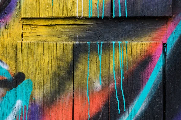 Wall wooden painted with different colors of paints. Close up.