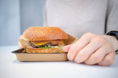 Burger, kızın önündeki masada yalanıyor. Kapat..