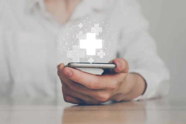 Conceito Saúde Mão Detém Smartphone Com Signo Médico Cruz Resumo — Fotografia de Stock