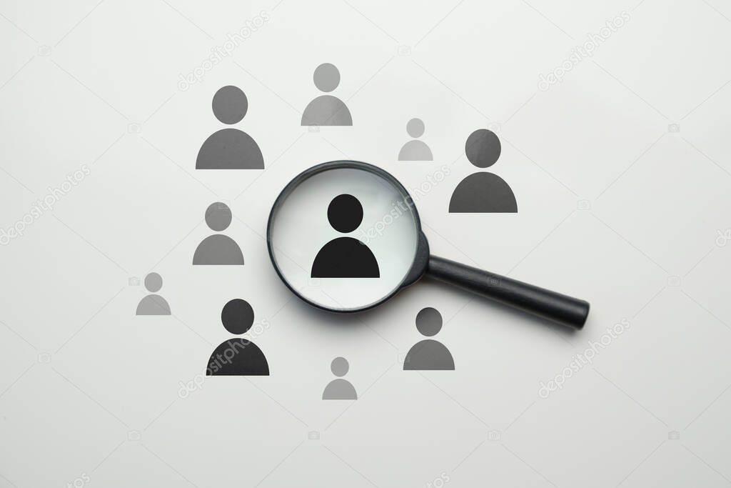 Employee search HR concept - magnifier with abstract employee on a white background. Close up.