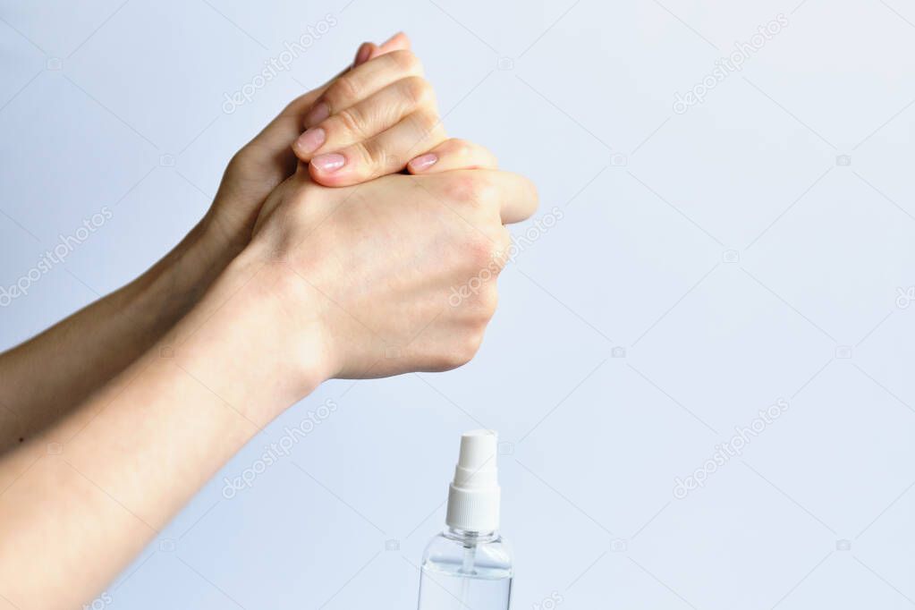 A man rubs his hands with an antiseptic on a white background. Close up.