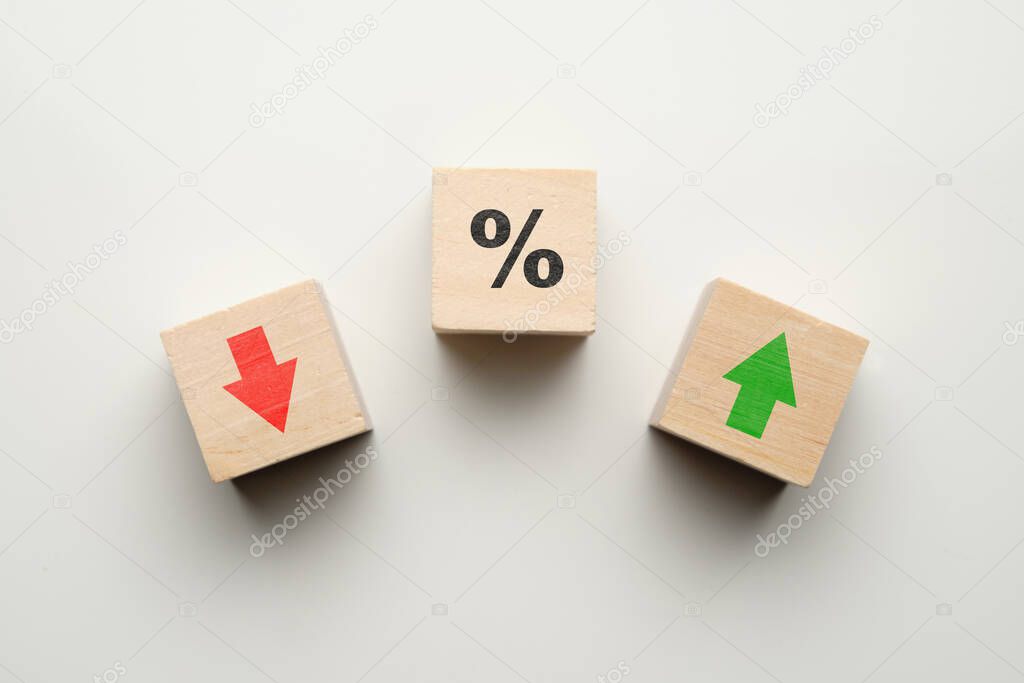 Percentage concept in finance increase or decrease with icons on wooden blocks. Close up.