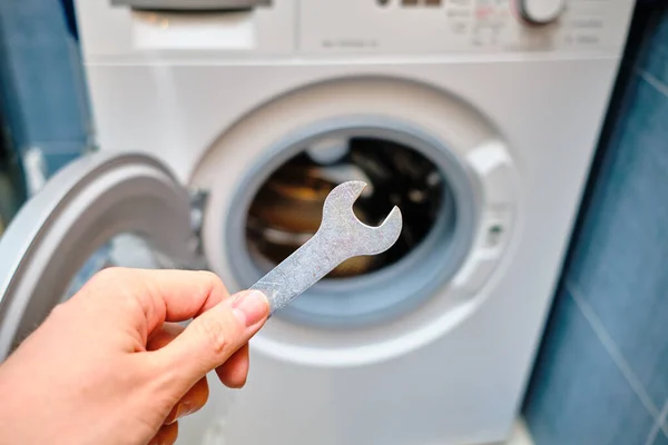 The concept of repairing a washing machine by worker in the bathroom. Close up.