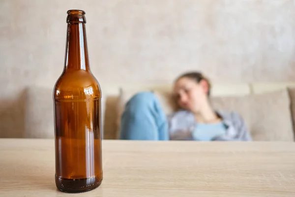 Girl drinks alcohol beer at home and is very drunk. Close up.