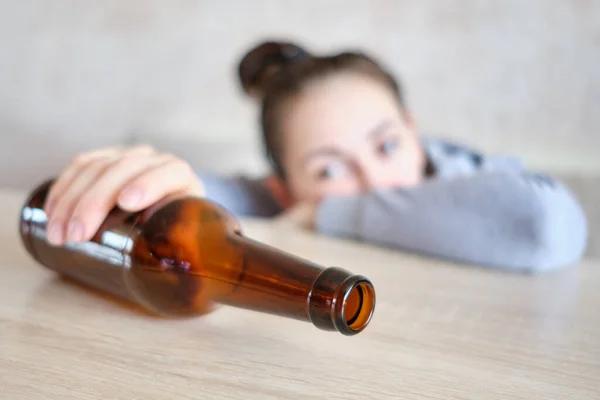 Девушка Грустно Смотрит Бутылку Алкоголем Закрыть — стоковое фото