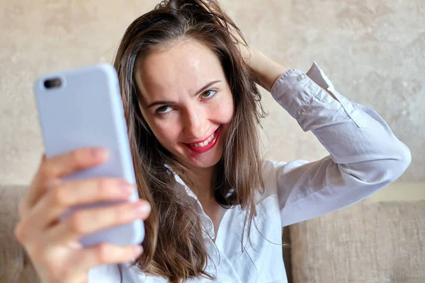 Drunk girl with smeared lipstick makes selfie photo. Close up.