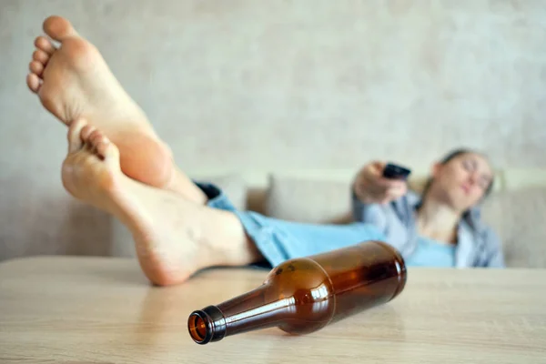 Пьяная Девушка Лежит Диване Переключает Каналы Телевизору Ноги Столе — стоковое фото