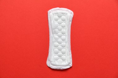 Kırmızı arka planda beyaz kadın pedi. Kapatın. Üst görünüm.