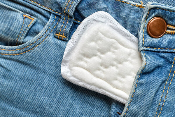 Women pad in the width of blue jeans. Close up.