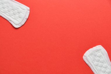 Kırmızı arkaplanda fotokopi alanı olan kadın pedleri. Üst görünüm.