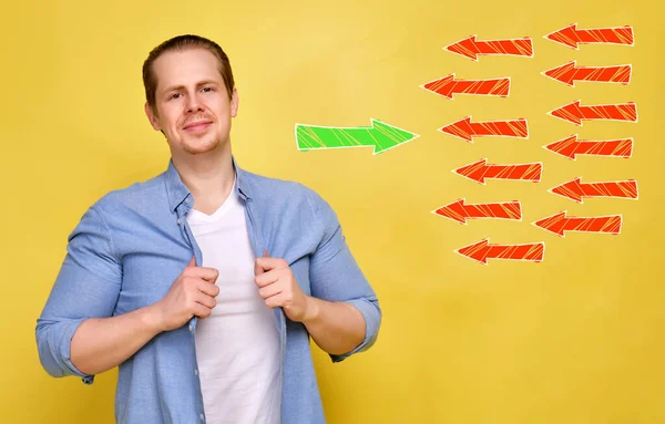 Ein Mann Im Hemd Auf Gelbem Grund Das Konzept Einer Selbstbewussten Person Gegen Die Offentliche Meinung Abstrakter Gruner Pfeil Gegen Viele Rote Nahaufnahme Kunstlerische Alt Stock Photo 348510670