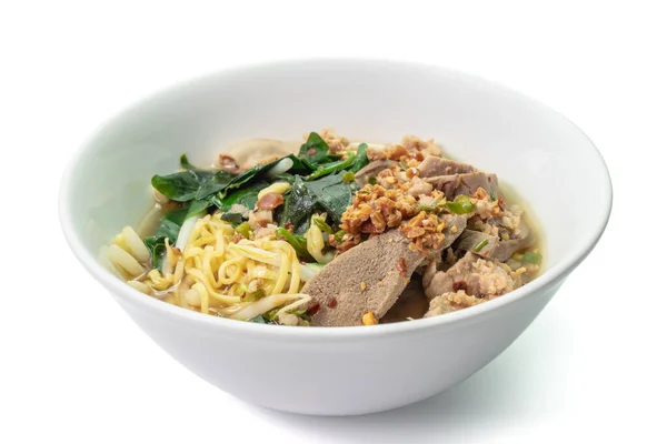 Tayland Tom Yum Baharatlı Erişte 'nin yakın çekimi sarmaşık kabağı yapraklı beyaz kase üzerinde.