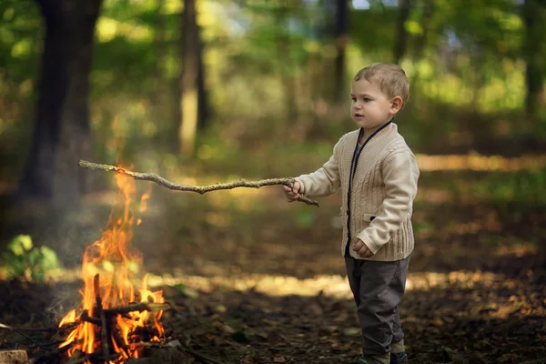 Niño jugando con fuego en el bosque — Foto de Stock