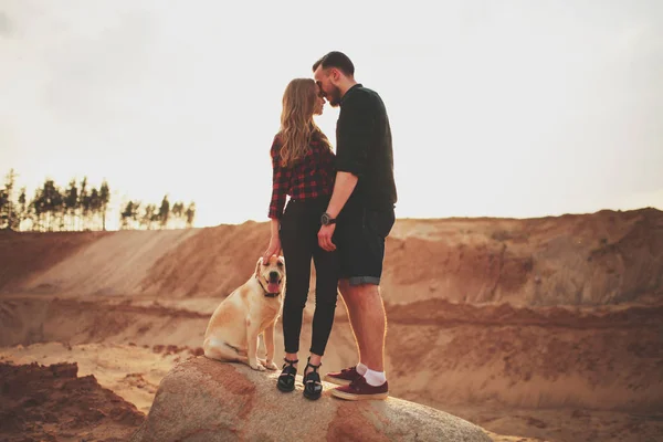 Lovers at sunset with cute labrador — Stock Photo, Image