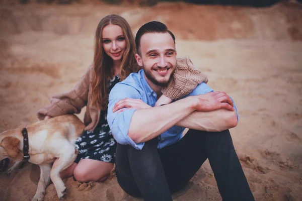 Amantes ao pôr do sol com labrador bonito — Fotografia de Stock