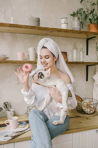 Young girl sitting on the table with her dog — Stock Photo, Image