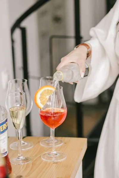Uma menina é derrama martini para seu coquetel vermelho com laranja. Festa Imagens De Bancos De Imagens Sem Royalties