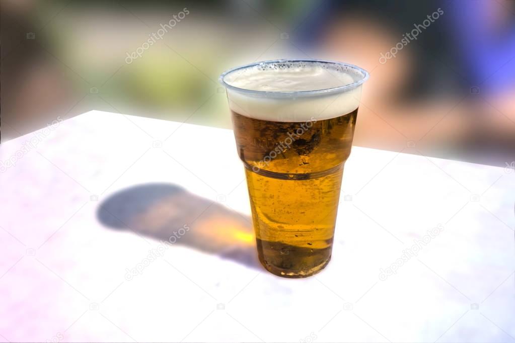 A glass of light beer on a white table