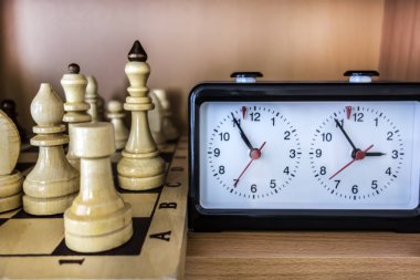 Satranç arka plan ile bir ahşap tahta, satranç taşları ve saat